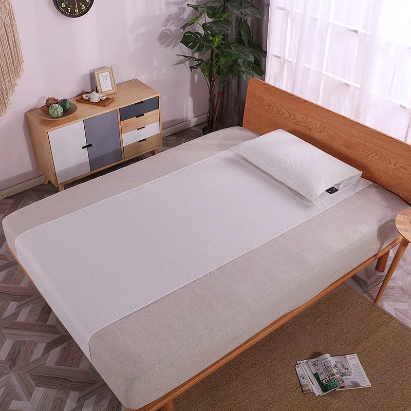 Interior view of a bedroom with a double bed, where our half-sized grounding sheet is positioned longitudinally from top to bottom, highlighting its sleek design and functional placement for nightly use