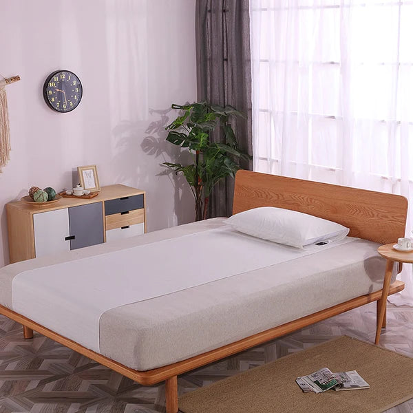 Double bed in a modern bedroom with our half-sized grounding sheet running lengthwise from top to bottom of the mattress, showcasing its unique positioning for effective earthing while sleeping.