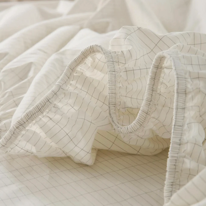 Image of a fitted grounding sheet laid on a king-sized bed, showcasing its ample coverage and subtle, natural color that blends with the room’s decor.